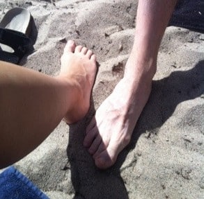 Fötter i sand på stranden
