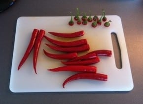En massa röd chili på en skärbräda. Gissa vad det ska blI? Chilifest.
