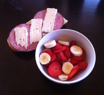 Frukost, smörgås med salami och brie, jordgubbar och banan