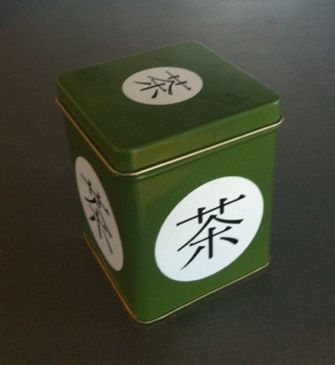 Grön plåtburk med kinesiska tecken
