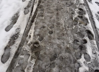 Slask på trottoaren efter snöfall.